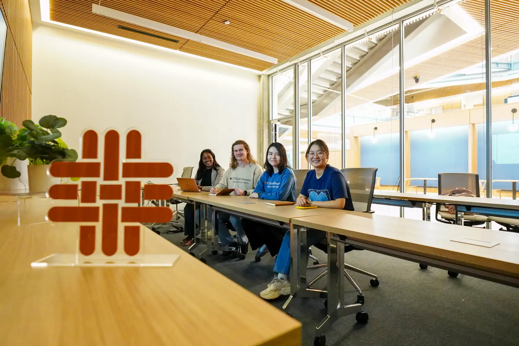 Students sitting at table looking at camera and smiling